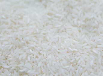 A detailed close-up shot of uncooked white rice grains, emphasizing texture and natural quality.