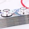 a pile of money with a stethoscope on top of it