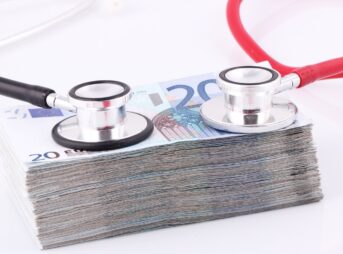 a pile of money with a stethoscope on top of it