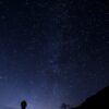 silhouette of man looking at milky way