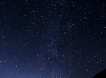 silhouette of man looking at milky way